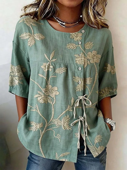 Flor | Blusa con bordado floral en relieve y lazada lateral